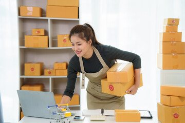 Online Business: An Asian woman meticulously prepares her online business orders, signing a package...