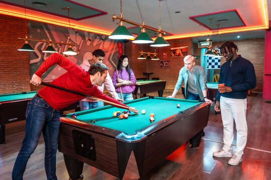 Friends playing billiards in entertainment venue