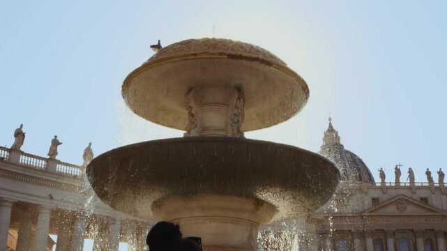 Vatican city, Rome, Italy - August 1 2024. Water cascades from the fountain, showcasing the magnificent St. Peter's Basilica in the backdrop
