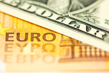 Ein Dollarschein liegt auf einem Euroschein