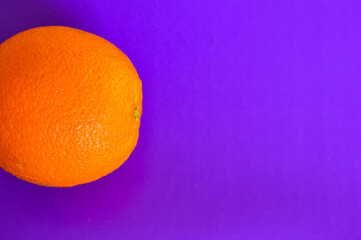 Fresh orange on vibrant purple background. Minimalist pop art style, healthy food concept, bold...