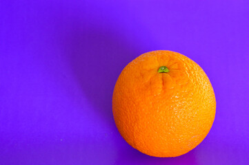 Fresh orange on vibrant purple background. Minimalist pop art style, healthy food concept, bold color contrast, creative composition, modern design trend.