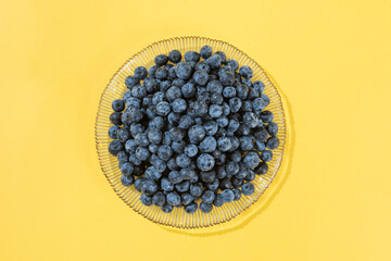 fresh blueberry fruit on yellow background.