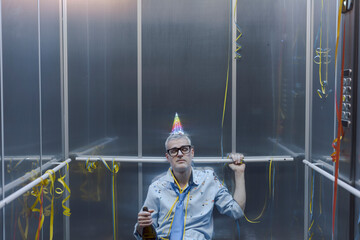 Sad office worker celebrating alone in the elevator