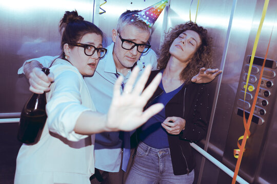 Drunk business people celebrating in the elevator