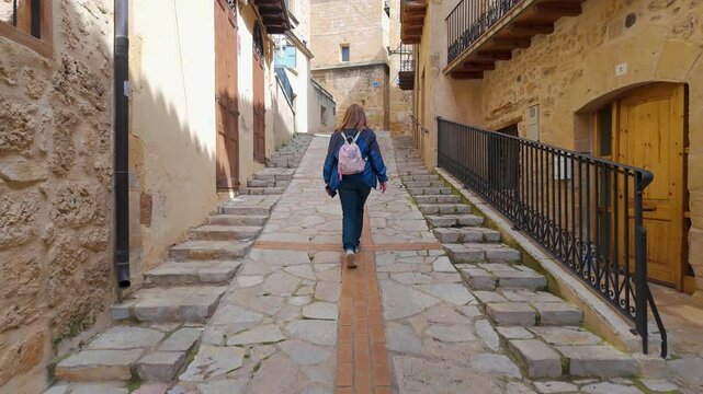 Tourist woman strolling through the steep streets of the picturesque village of Beceite, Teruel, Aragon.