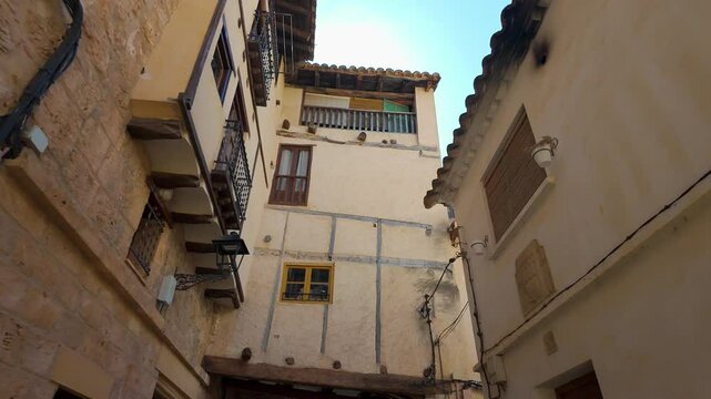 The sun rising between the facades of the old stone houses in the village of Beceite, Teruel.