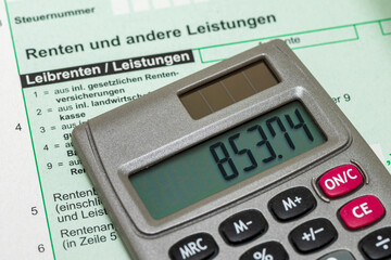 Auf einem Steuerformular für Renten liegt ein Taschenrechner
