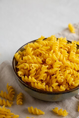 Raw Dry Organic Fusillini Pasta in a Bowl, side view.