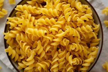 Raw Dry Organic Fusillini Pasta in a Bowl, top view.