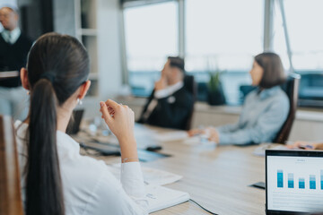 A diverse group of business colleagues engaged in a dynamic meeting, discussing ideas and analyzing...