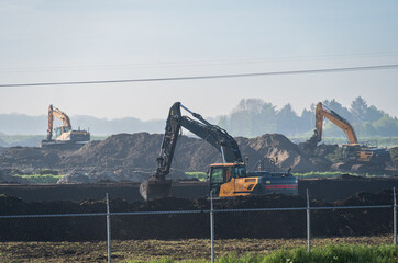 Excavators doing ground work on a construction site in Meerstad.