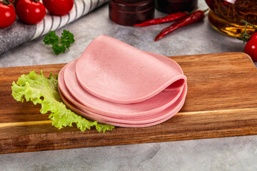 Sliced boiled sausage over board