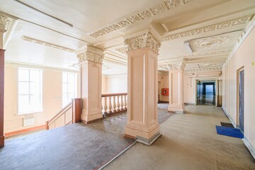 interior apartment public place,Ornate hall with peach walls, decorative columns and ceilings, windows, and staircase.
