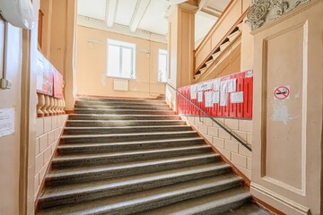 Ornate indoor staircase with vintage design, featuring stone steps, painted wood, and decorative...