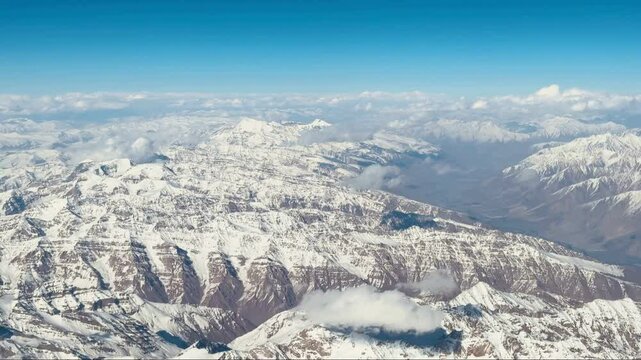 Snow-covered Pamir mountains aerial view under blue sky