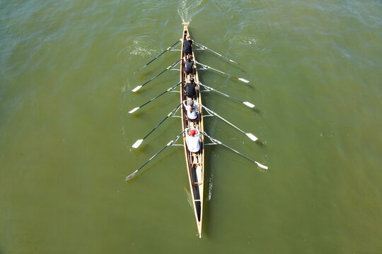 Academic rowing, four athletes with a coxswain sail in a boat on open water. Academic rowing competition.