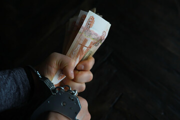 Handcuffs behind, five thousand rubles. Concept of corruption