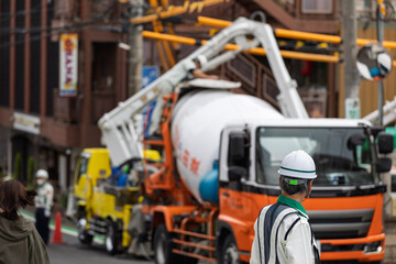 工事車両の停車する道路の交通を整理する交通誘導員	