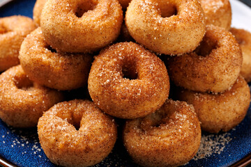Mini cinnamon sugar donuts on blue plate