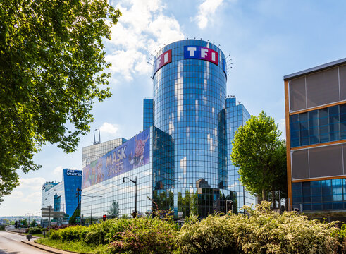 Boulogne-Billancourt, France - April 28, 2025: The TF1 tower, seat of the French television channel, built by Bouygues in 1992 after Roger Saubot, displaying a huge banner for the Mask Singer TV show.