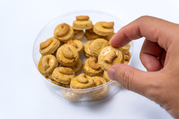 Delicious Round Cashew Cookies Topped with Cashew Nuts, Arranged  in a Traditional Woven Basket, isolated on  White, Perfect for Eid Al-Fitr Celebrations, Selective Focus