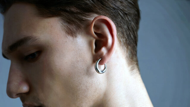 Detailed View of a Mans Ear with Silver Earring and Hair Detail