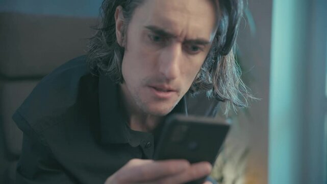 Man Experiencing Anxiety and Frustration While Engaged with His Phone