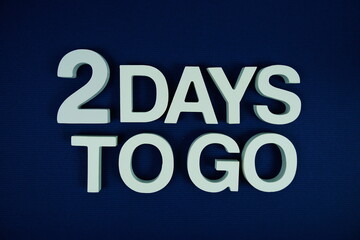 2 Days to go alphabet letters top view on navy blue background