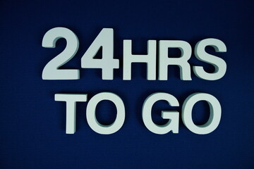 24 Hrs to go alphabet letters top view on navy blue background