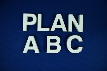 Plan A,B,C alphabet letters top view on navy blue