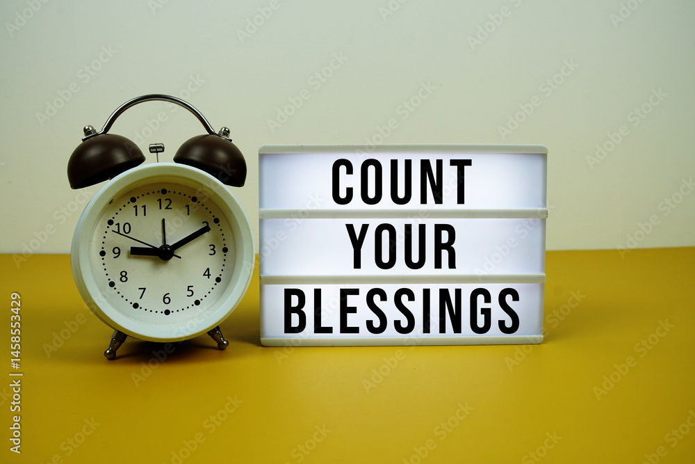 Poster countyour blessings text on light box with alarm clock on yellow background