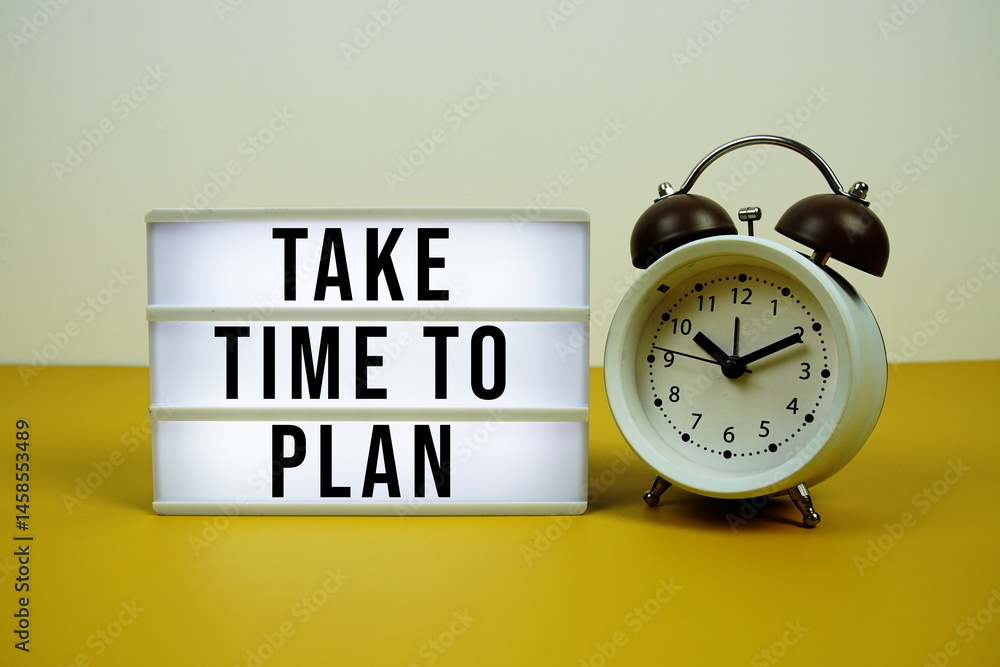 Poster take time to plan text on led lightbox with alarm clock on yellow background