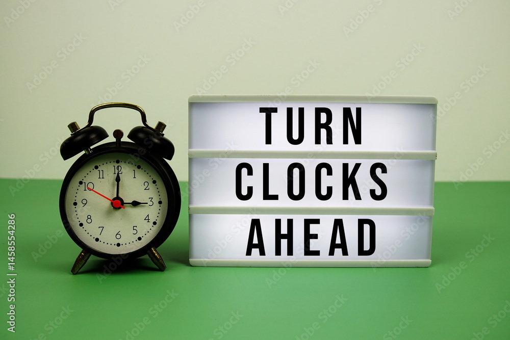 Poster turn clocks ahead text on light box with alarm clock on green background