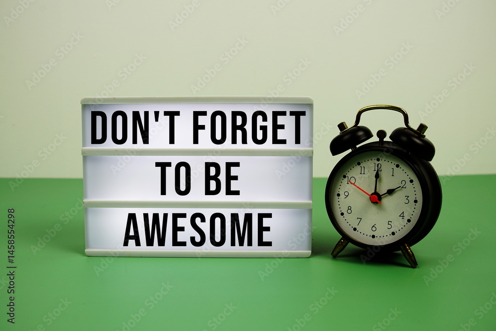 Poster don't forget to be awesome text on light box with alarm clock on green background