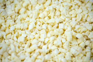 Close-up of shock-frozen chopped garlic pieces with a thin ice coating. Are prepared for retail packaging to ensure extended shelf life in supermarkets and maintain perishable harvest quality.