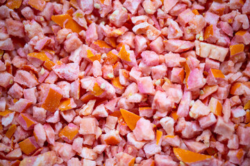 Close-up of shock-frozen diced red tomatoes with a thin ice coating. Are prepared for retail packaging to ensure extended shelf life in supermarkets and maintain perishable harvest quality.