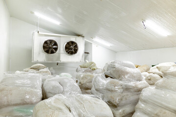 A cold storage warehouse for food products frozen using the shock-freezing method. The products are packaged in bags and placed on wooden pallets for organized storage and distribution