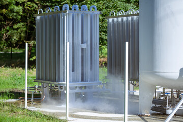 Obraz premium An oxygen station that produces and supplies medical oxygen to a hospital. The station includes radiators and a large white cylinder containing liquefied oxygen for distribution.