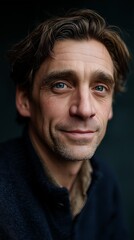 Fototapeta premium Moody close-up of a pensive man with blue eyes and visible wrinkles, wearing a gray sweater and staring directly at the camera. 