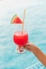 Refreshing Watermelon Juice by the Poolside in Summer. Close-up of a Woman’s Hand Holding a Watermelon Punch