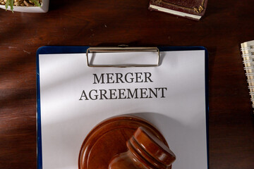 Merger Agreement Document Placed on Wooden Desk with Gavel