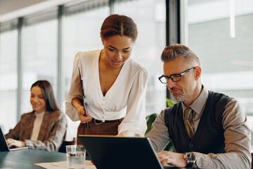 A dedicated business team working together on a project within a modern office environment to...