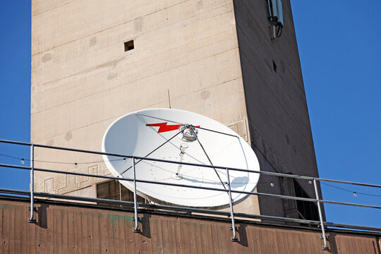 Stockholm, Sweden - May 23, 2023: Satellite Dish Mounted on Urban Building Against Blue Sky