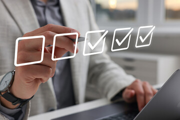 Approved. Man using laptop and checking boxes on virtual screen, closeup