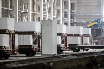 Industrial production of aerated concrete blocks, AAC blocks (Autoclaved aerated concrete), Fly ash or Grey Cement Fly Ash Bricks. Carts with cut blocks are cured after processing in an autoclave.