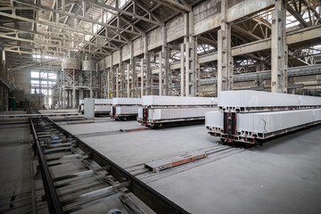 Obraz premium Industrial production of aerated concrete blocks, AAC blocks (Autoclaved aerated concrete), Fly ash or Grey Cement Fly Ash Bricks. Autoclaves and trolleys with cut blocks. General view of the workshop