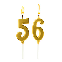Burning golden cake candles composing number 56 on white background. Festive decoration for...
