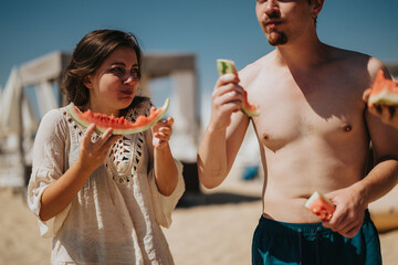 Two friends enjoying fresh watermelon together on a beautiful and sunny day at the beach, capturing the joy of summer and great companionship.