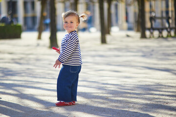 Adorable toddler girl walking in a park in Paris, France